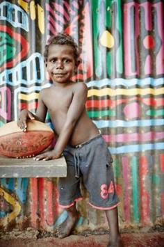 Young boy Tiwi Islands.  The Tiwi Islands are part of the Northern Territory, Australia, 80 km to the north of Darwin where the Arafura Sea joins the Timor Sea. They comprise Melville Island, Bathurst Island, and nine smaller uninhabited islands, with a combined area of 8,320 square kilometres (3,212 sq mi). Inhabited before European settlement by the Tiwi indigenous Australians, there are approximately 3,000 people on the islands. (wiki)