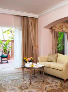 Rooms feature the hotel's signature pink with white detailing.