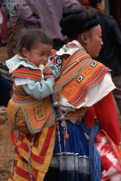 China | A Miao mother attending the Little Flower Miao festival in Nankai transports her infant in a back sling. Guizhou Province | © Keren Su/Corbis