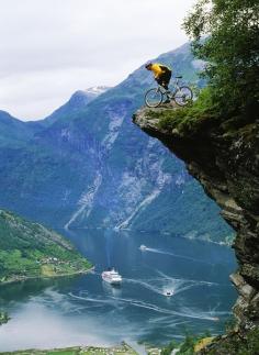 Mountain biker at Flydalsjuvet above Geiranger Fjord (by NordicPhotos)