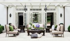 Clean, white outdoor space with a covered pergola and drum side tables give a nice calming touch.