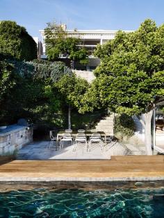 Outdoor table area alongside hardwood and tiled pool.