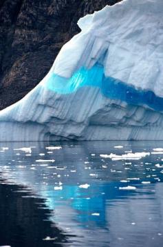 
                    
                        A ribbon of clear blue ice runs through an iceberg and is reflected in the sea. West Greenland
                    
                