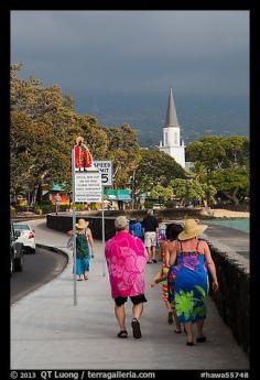 
                    
                        Beachgoers walking past ironman triathlon sign, Kailua-Kona. Hawaii, USA
                    
                