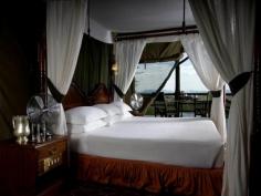 
                    
                        Vintage fans, and white canopy bed. Kirawira Luxury Tented Camp  Serengeti National Park, Tanzania
                    
                