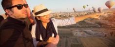 Couple on a hot-air balloon looking out upon the volcanic valley of Cappadocia, Turkey