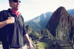 Man in sunglasses walking past Machu Picchu in Peru